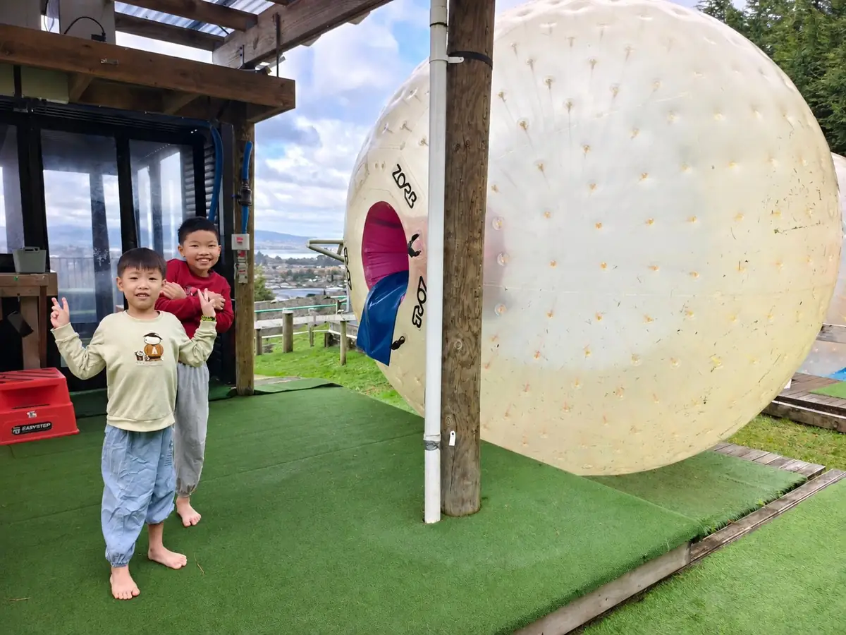 兩兄弟在紐西蘭 ZORB 戶外體驗設施前合照